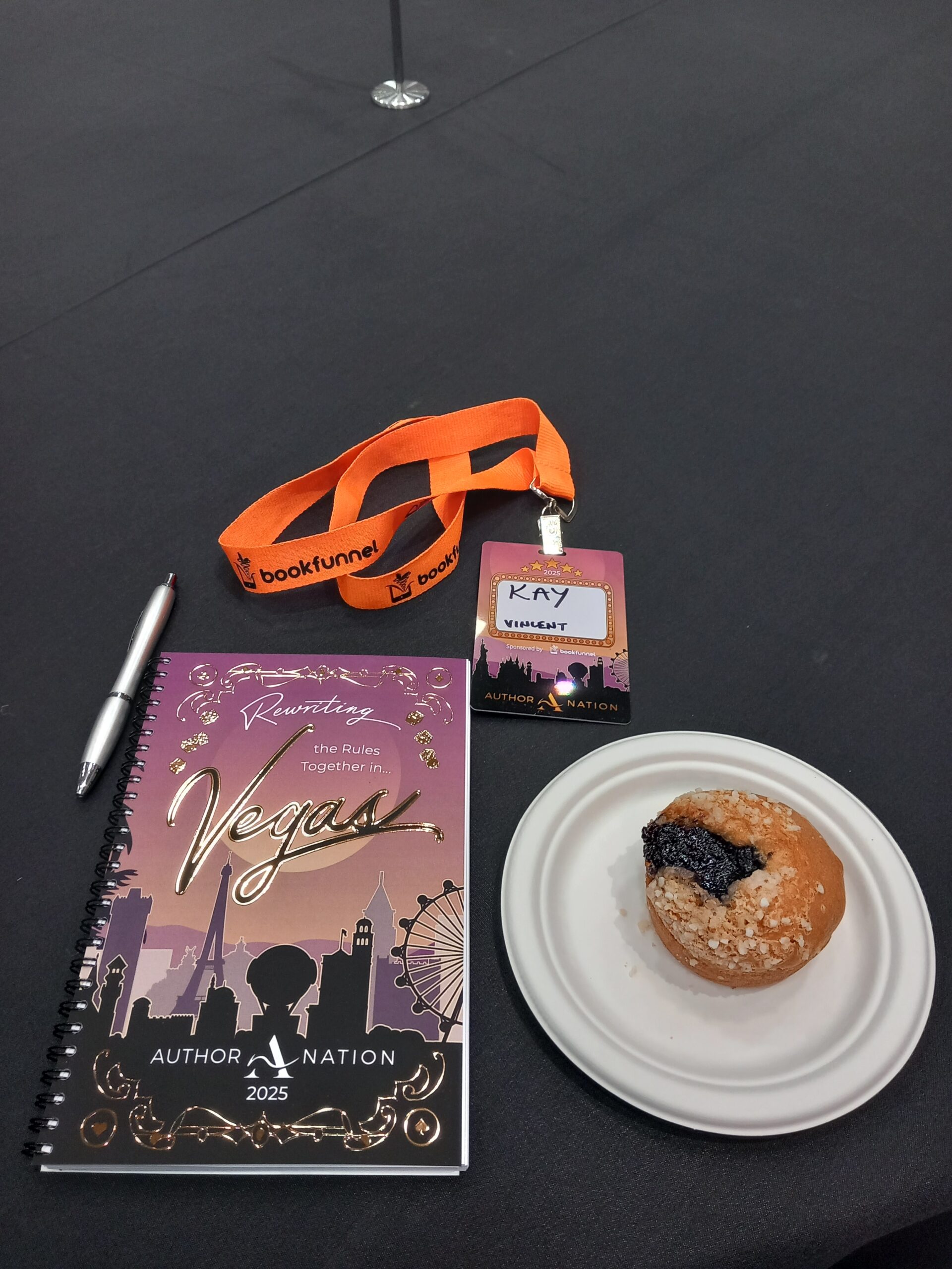 author nation badge, notebook, and muffin