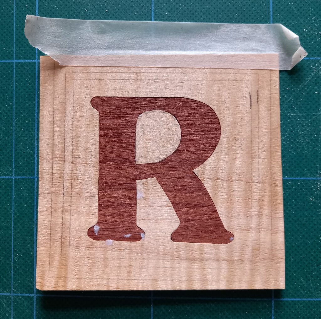 initial letter R marquetry coaster from front
